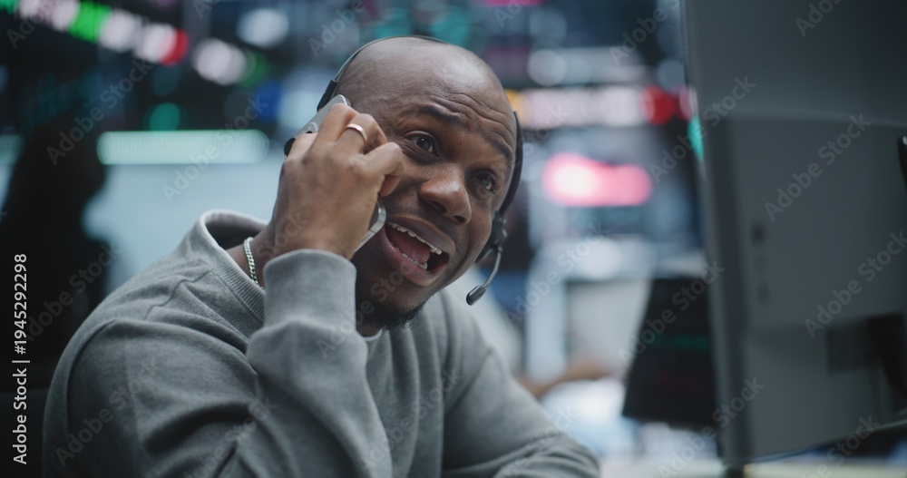 Obraz premium Black Male Broker Engages in Heated Smartphone Conversation, Gesturing Wildly Falling Charts on Multi Monitors. Man Pure Despair, Panic Witnesses Massive Market Collapse, Profit Loss in Trading Hub.