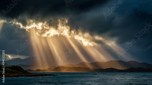 Dramatic sunbeams breaking through storm clouds over coastal forest island