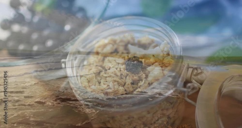 Showing jar with metal clasp sitting on shore, foam sweeping oats and berry, thumb nearing clasp