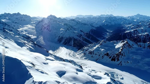 Vast snow covered mountain range and high peaks, immense glaciers flow through deep valleys. Breathtaking cold winter alpine landscape