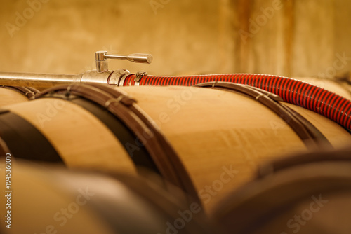 Wine transfer pipe on barrels in cellar