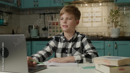 Boy Taking Online Lesson on Laptop and Writing in Notebook at Home