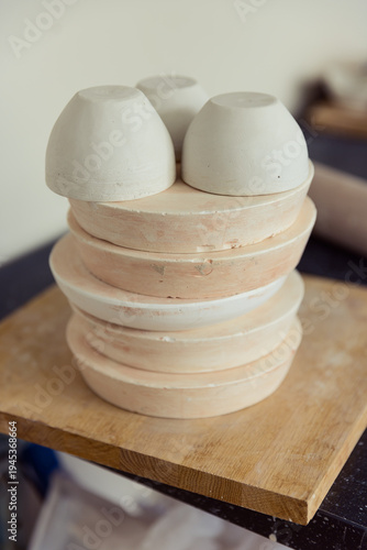 фотографія Stack of handmade ceramic plaster molds and clay bowls in a pottery studio