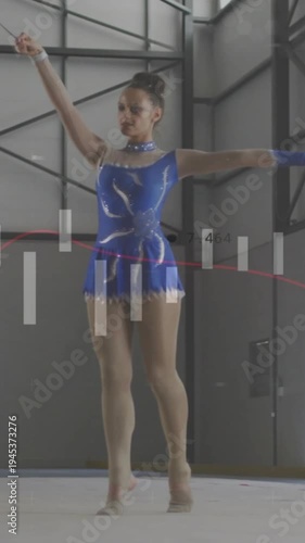 Vertical video: Teen rhythmic gymnast starting by sweeping ribbon, rotating on mat for competition