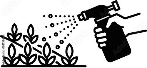 Hand spraying water on small plants to aid growth