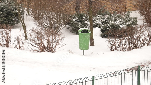 Teren wokół bloku z widocznym ogrodzeniem i śmietnikiem.