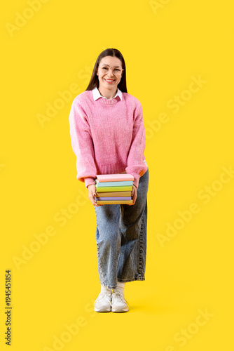 Young woman with stack of b...
