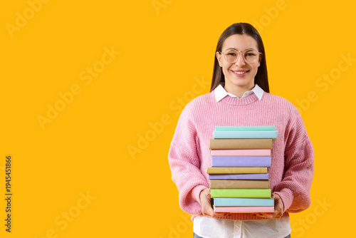 Young woman with stack of b...
