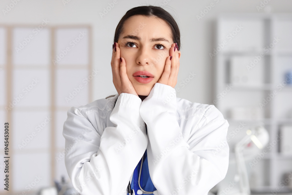 Wall Mural Female doctor suffering from burnout in clinic