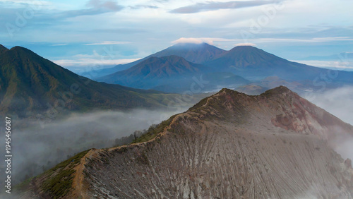 Foto Ijen Volcano sunrise panorama with crater ridge and gas cloud