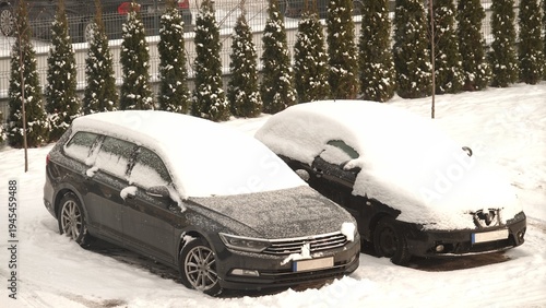 Auta na parkingu przysypane białym śniegiem w okresie zimowym
