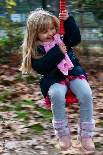 little blonde girl having fun on the zipline