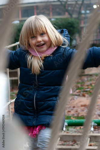 little blonde girl playing in the park