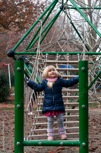little blonde girl playing in the park