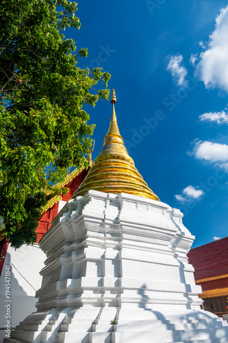 Golden stupa towers rising toward blue sky in Buddhist temple complex in Chiang Mai Thailand. Sacred architecture symbolizing faith, spirituality and rich cultural heritage of Southeast Asia.