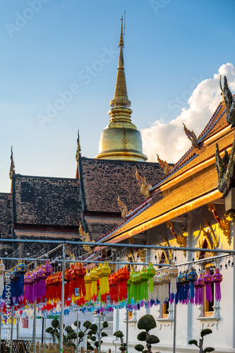 Exterior view of Wat Phra Singh Woramahawihan temple in Chiang Mai Thailand at sunset. Historic Buddhist architecture bathed in warm light, highlighting cultural heritage and serene atmosphere.