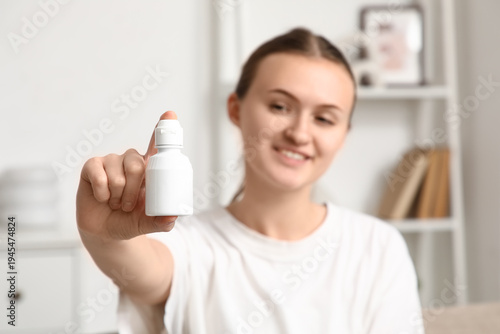 Young woman with eye drops ...