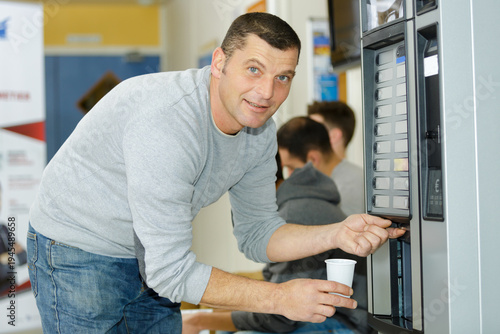 Cuadro en lienzo man getting drink from vending machine
