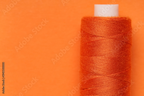Spool of thread on orange b...