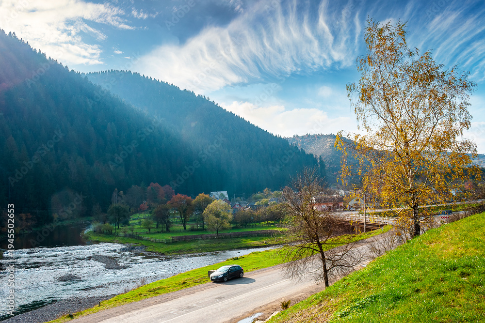 Obraz premium mountain landscape during fall season. rural scenery of transcarpathia with rika river in the afternoon light. picture of a countryside road through valley near soimy village for travel background