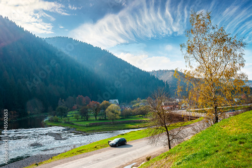 mountain landscape during fall season. rural scenery of transcarpathia with rika river in the afternoon light. picture of a countryside road through valley near soimy village for travel background