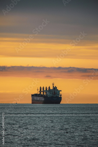 Stock images of Ship carrying containers with crude oil barrels from the harbour. Ship blocked in harbour.