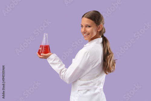 Cute teenage happy scientist with flask of reagent on purple background