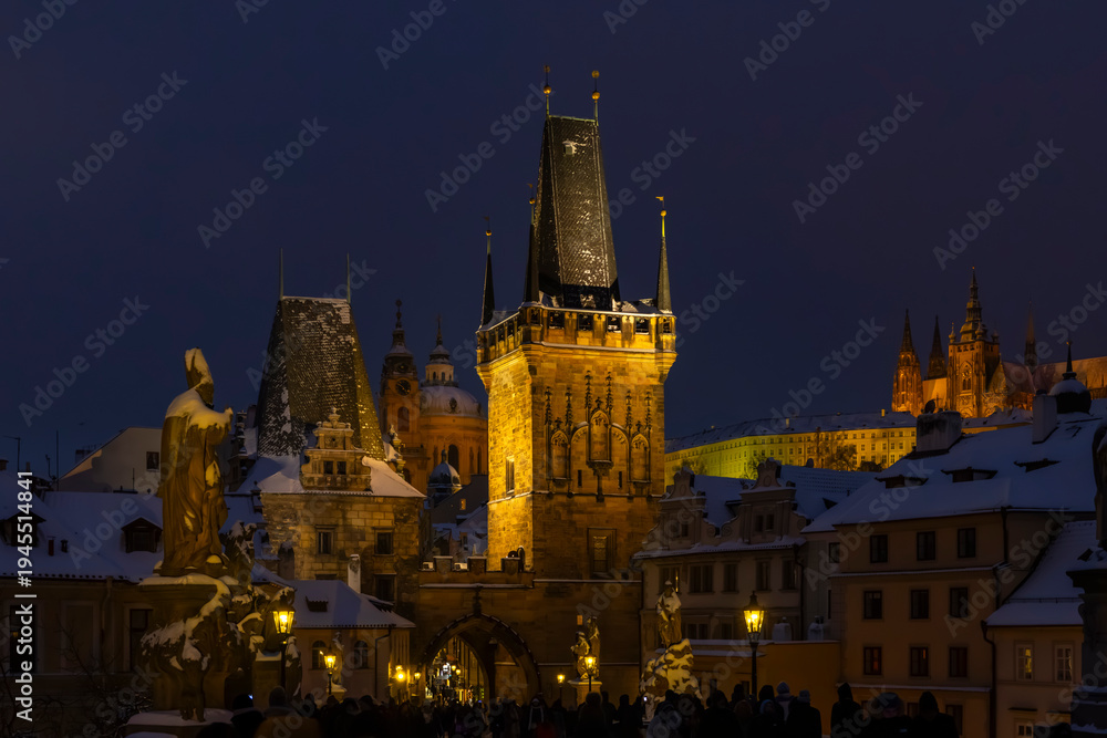 Obraz premium Charles Bridge Lesser Town Bridge Tower illuminating snowy night