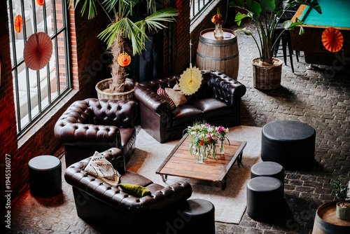 Cozy lounge corner leather armchair tropical plants, industrial loft interior