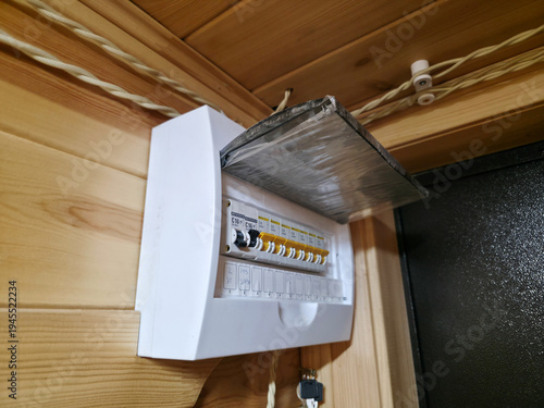 Electrical distribution board on wooden wall. Household circuit breaker box for power control. Electric panel with switches in residential house. Safety electricity equipment installation.