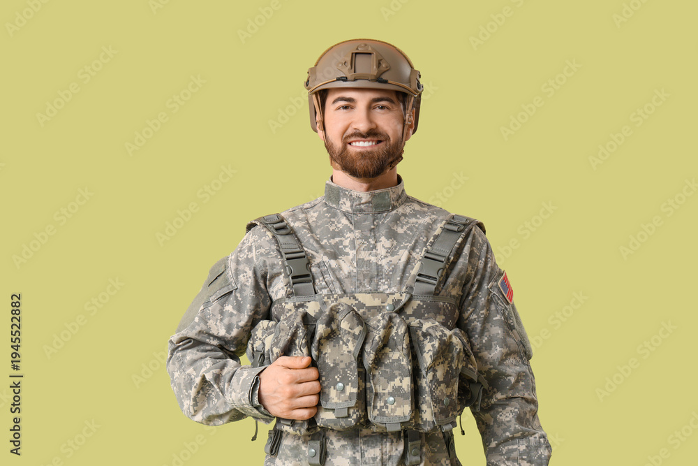 Obraz premium Young happy male soldier in uniform on green background