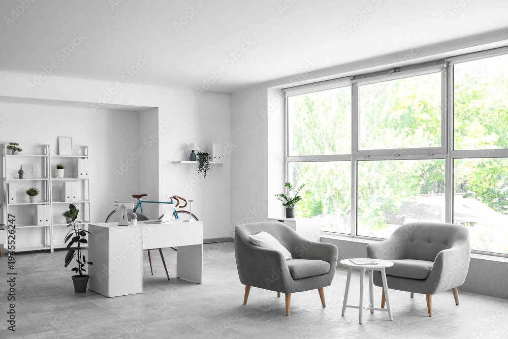 Fototapeta premium Interior of home office with workplace, bicycle and armchairs