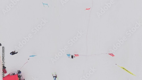 Aerial view of skier crossing finish line in parallel slalom race on snowy mountain course