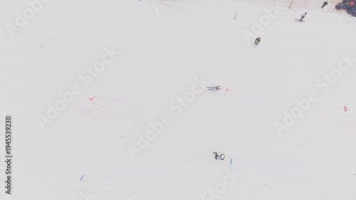 Top view drone shot of two skiers racing parallel slalom on snowy competition slope