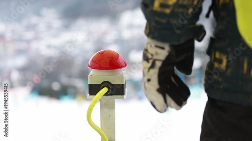 Hand pressing start button to launch ski race at alpine slalom competition