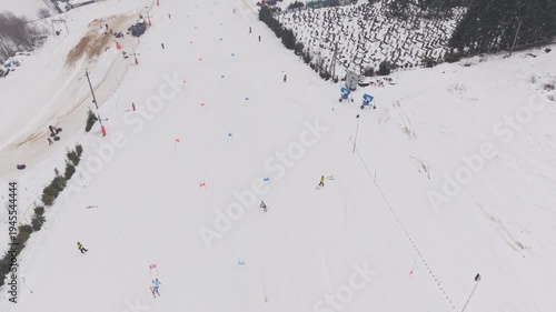 Top view drone shot of two skiers racing parallel slalom on snowy competition slope