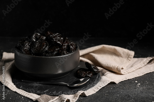 Bowl with dried prunes on b...