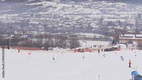 Drone following two skiers racing parallel slalom on snowy mountain competition slope