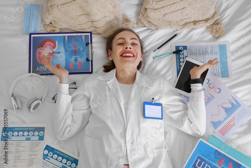 Happy female medical student preparing for exams and lying on bed at home