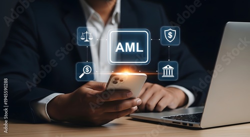 Business person using a smartphone and laptop while analyzing anti-money laundering compliance with digital tools.