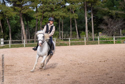 Horse riding - portrait of lovely equestrian on a white horse