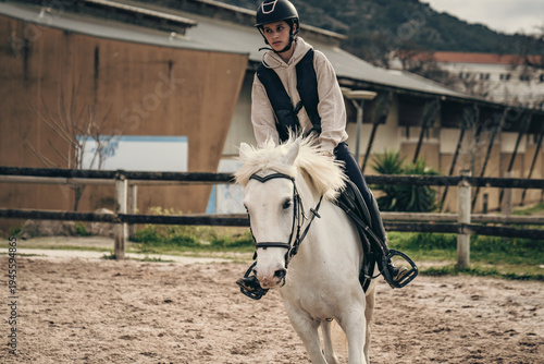 Horse riding - portrait of lovely equestrian on a white horse