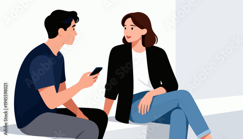 Two people sit facing each other. One holds a phone, gesturing softly. The other listens attentively, smiling. Their body language suggests casual connection