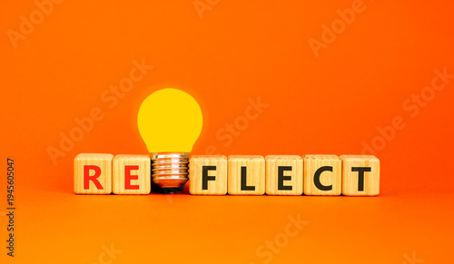 Reflect word symbol. Concept word Reflect on beautiful wooden blocks. Beautiful orange background. Beautiful yellow light bulb. Business psychological reflect word concept. Copy space.