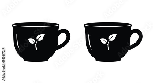 Two black teacups with leaf designs a striking silhouette