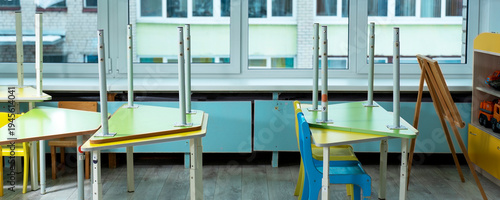 Foto Children's classroom with tables inverted on chairs, reflecting temporary closur