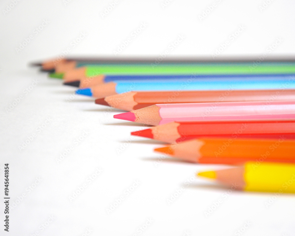 Fototapeta premium Colorful Colored Pencils in Row on White Background Close-Up