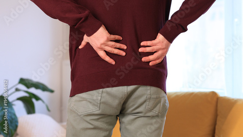 Man with hip, back, spine and sciatica pain at home.