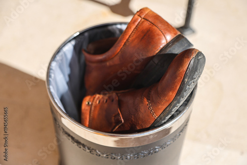 Принти на полотні Old leather men shoes discarded a trash bin, symbolizing wear and tear, and the passage of time, reflecting on the journey of life and fashion