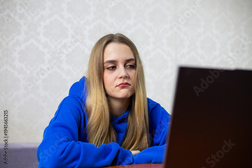 Foto Disappointed blonde girl watches boring football match with 0-0 score